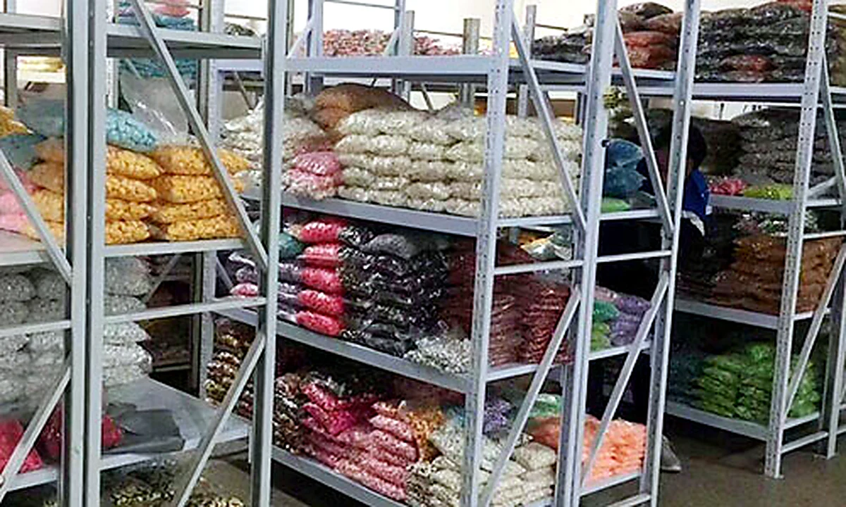 Organized warehouse shelves containing packed colorful craft materials